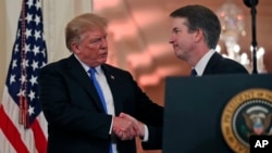 Presiden Amerika Serikat Donald Trump menjabat tangan Hakim Brett Kavanaugh, yang dinominasikannya sebagai Hakim Agung , di Gedung Putih, Washington DC, Senin, 9 Juli 2018. 