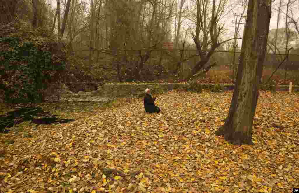 Seorang pria lansia Muslim-Kashmir melakukan shalat di atas daun-daun kering pada hari yang dingin dan berkabut di Srinagar, Kashmir-India.