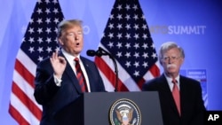 FILE - President Donald Trump, left, is flanked by national security adviser John Bolton, right during a press conference after a summit of heads of state and government at NATO headquarters in Brussels, Belgium, July 12, 2018.