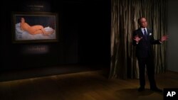 Kevin Ching, CEO of Sotheby's Asia. speaks next to a painting "Nu couche" by Italian artist Amedeo Modigliani during Sotheby's auction press preview in Hong Kong, April 24, 2018. 