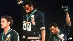 Tommie Smith (centre) et John Carlos, le 16 octobre 1968 aux JO de Mexico. (Archives AP)