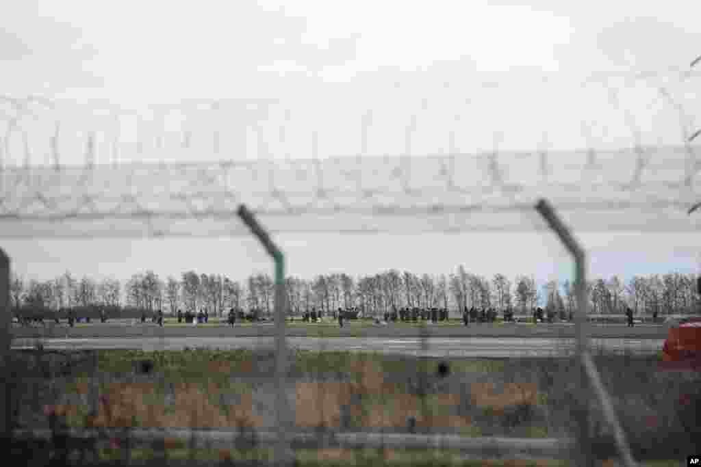 Officials and investigators search a plane crash site in Kazan airport, Russia, Nov. 18, 2013. 