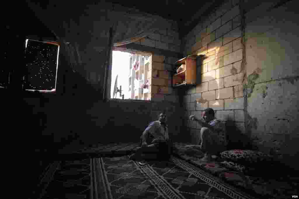 Walid Abu Hafez (L) is seen with a friend at Walid's home in the Ouzai complex, which houses more than 130 families in the Lebanese city of Saida. (Photo - J. Owens/VOA)