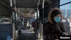 Žena nosi masku u autobusu u Pekingu