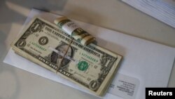 Tips, money collected from a customer donation fund and a last paycheck for employees laid off from Farley’s East cafe, that closed due to the coronavirus outbreak, sits on a counter at the cafe in Oakland, California, March 18, 2020.