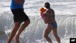 FILE - A mother and her daughter cool off at Playa Del Rey beach in Los Angeles, California, Feb. 12, 2016.