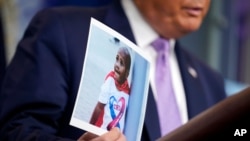 ARHIVA - Predsednik Donald Tramp drži fotografiju četvorogodišnjeg dečaka Ledženda Talifera na konferenciji za novinare u Vašingtonu (Foto: AP)