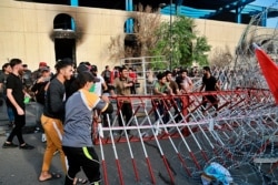 Anti-government protesters open the bridge leading to the Green Zone during a demonstration in central Baghdad, Oct. 25, 2019.