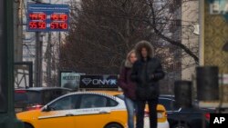 People pass by a display with exchange rates in downtown Moscow Nov. 10, 2014.