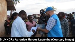 Au centre de réception de Mussungue, dans le nord-ouest de l’Angola, des employés du HCR distribuent des vivres - y compris du maïs, du riz, des fèves, de l’huile, du sel et des sardines – aux réfugiés congolais ayant fui une éruption de violence dans la région du Kasaï, 30 avril 2017. © HCR / Adronico Marcos Lucamba