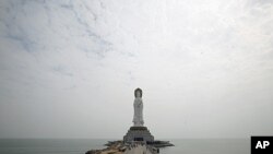 Tourists walk towards a 108-meter high Buddhist statue at Nanshan Cultural Center, about 60km (37 miles) west of Sanya, in south China's Hainan Island province. (file photo)