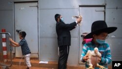 An ultra-Orthodox Jewish man wearing a face mask during a nationwide three-week lockdown to curb the spread of the coronavirus, swings a chicken over his head as part of the Kaparot ritual, in Bnei Brak, Israel, Sept 24, 2020. 