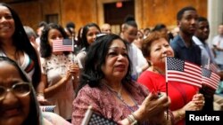 FILE - New citizens stand during a U.S. Citizenship and Immigration Services (USCIS) naturalization ceremony at the New York Public Library in Manhattan, New York, July 3, 2018. 