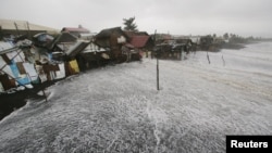 Ombak kuat menghantam rumah-rumah di pinggir pantai akibat Topan Hagupit yang melanda Legazpi, provinsi Albay, Filipina, 7 Desember 2014. 