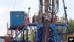 FILE - A crew works on a gas-drilling rig at a well site for shale-based natural gas in Zelienople, Pa., June 25, 2012.