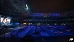 មនុស្ស​ម្នា​កំពុង​មើល​កុន​ដោយ​អង្គុយ​នៅ​ក្នុង​ឡាន​របស់​ខ្លួន​ នៅ​ឯ​កីឡដ្ឋាន​បាល់​ទាត់ Palmeiras នៅ​ទីក្រុង Sao Paulo ប្រទេស​ប្រេស៊ីល កាល​ពី​ថ្ងៃ​ទី​២៥ មិថុនា ២០២០។