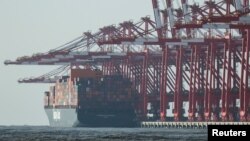 Kранови стојат во близина на товарен брод во пристаниште надвор од Шангај, 7 февруари 2025 година