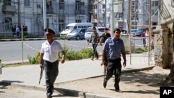 Polisi mengamankan daerah di ibukota Tajikistan, Dushanbe, tempat beberapa anggota pasukan khusus dan polisi lalu lintas ditembak sampai mati (4/9). (AP/Peter Leonard)