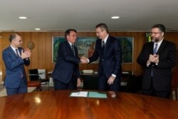 Brazil's President Jair Bolsonaro shakes hands with the new head of the federal police Rolando Alexandre de Souza at the Planalto Palace in Brasilia, Brazil, May 4, 2020.