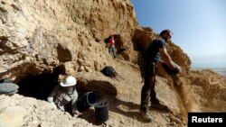 Volunteers and archaeologists work at an archaeological dig near caves in the Qumran area in the Israeli-occupied West Bank January 15, 2019. (REUTERS/Ronen Zvulun)