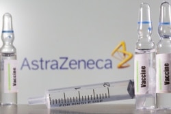 A test tube labeled with the Vaccine is seen in front of AstraZeneca logo in this illustration, Sept. 9, 2020.