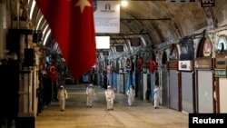 Para pekerja mengenakan baju hazmat menyemprotkan cairan disinfektan di Grand Bazaar untuk mencegah penyebaran virus corona (COVID-19) di Istanbul, Turkey, 25 Maret 2020. 