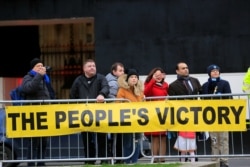 People stand behind a banner supporting the results of the general election, in London, Britain, Dec. 13, 2019.