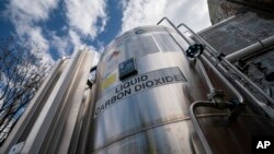 FILE - A liquid carbon dioxide containment unit stands outside the fabrication building of Glenwood Mason Supply Co. on April 18, 2023, in New York.