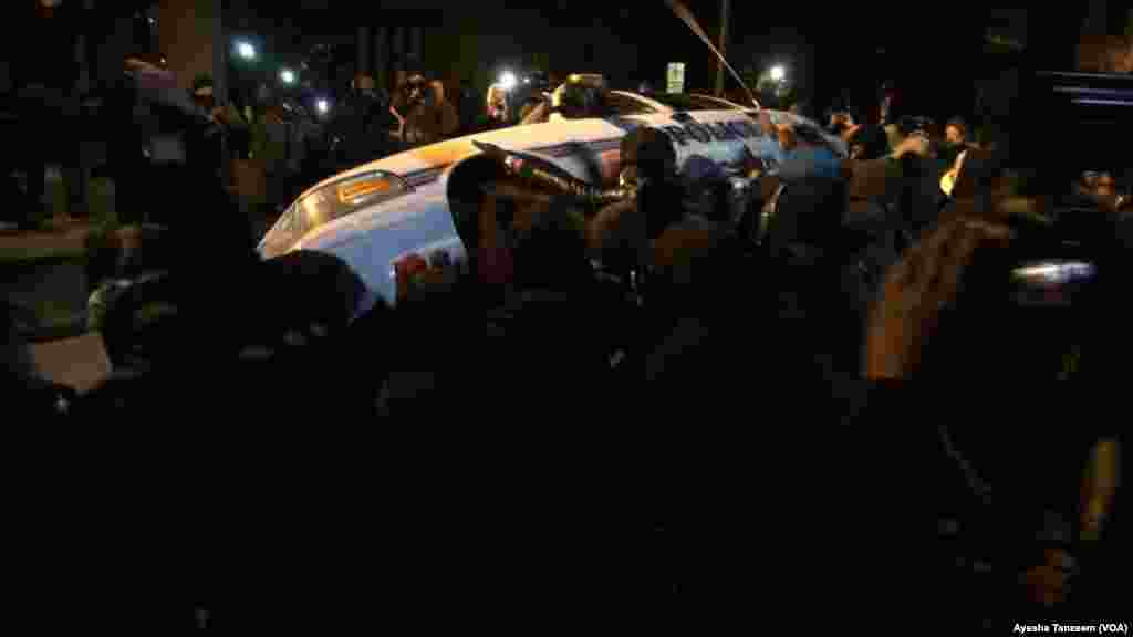 In a second night of violence following a grand jury's decision not to indict a white police officer in the shooting death of a black teenager, protesters attack and turn over a police car outside Ferguson City Hall, in Ferguson, Missouri, Nov. 25, 2014.