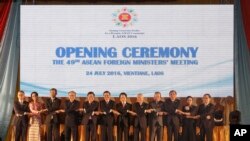 រូបឯកសារ៖ នាយក​រដ្ឋ​មន្ត្រី​ឡាវ​លោក Thongloun Sisoulith (រូប​ទី​៦​ពី​ឆ្វេង) និង​រដ្ឋមន្ត្រី​ការបរទេស​ឡាវ​លោក Saleumxay Kommasith (រូប​ទី​៦​ពី​ស្តាំ​) ឈរ​ចាប់​ដៃ​គ្នា​ជាមួយ​រដ្ឋមន្ត្រី​ការបរទេស​នៃ​ប្រទេស​ជា​សមាជិក​អាស៊ាន​ដទៃ​ទៀត ក្នុង​ពិធី​បើក​កិច្ច​ប្រជុំ​ថ្នាក់​រដ្ឋមន្ត្រី​លើក​ទី​៤៩ នៅ​ក្នុង​ទី​ក្រុង​វៀងច័ន្ទន៍ ប្រទេស​ឡាវ ថ្ងៃ​ទី​២៤ ខែ​កក្កដា ២០១៦។ (រូបភាព៖ AP/Sakchai Lalit)