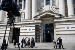 FILE - Journalists gather outside County Hall in central London, England, June 5, 2019.