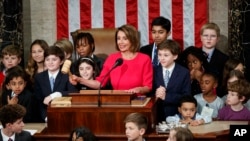 Ketua DPR AS Nancy Pelosi, dikelilingi oleh cucu dan anak-anak lainnya mengetukkan palu (gavel) di mimbar ruang sidang Gedung Capitol, Washington, D.C., 3 Januari 2019. (AP Photo/Carolyn Kaster)