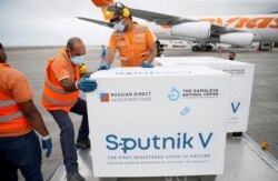 FILE - Workers take care of the shipment of Russia's Sputnik V vaccine at the airport in Caracas, Venezuela, March 29, 2021.