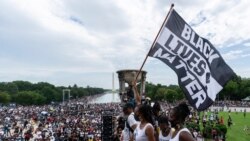지난해 마틴 루터 킹 목사의 워싱턴 행진 연설 57주년을 맞아 링컨기념관에서 열린 집회 참가자가 '흑인의 목숨도 소중하다(Black Lives Matter)' 운동 깃발을 들고 있다. (자료사진)