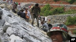 In this Oct. 6, 2012 photo, local workers adjust stones at another dam construction site by China National Heavy Machinery Corporation on the Tatay River in Koh Kong province, some 210 kilometers (130 miles) west of Phnom Penh, Cambodia.