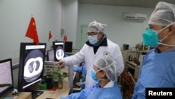 Petugas medis memeriksa gambar pemindaian CT (computed tomography) dari seorang pasien di RS Zhongnan, Universitas Wuhan yang terdampak wabah virus corona di Wuhan, provinsi Hubei, China, 2 Februari 2020.
