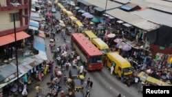 FILE - In this photo taken June 20, 2016, pedestrians shop at a market in Lagos, Nigeria.
