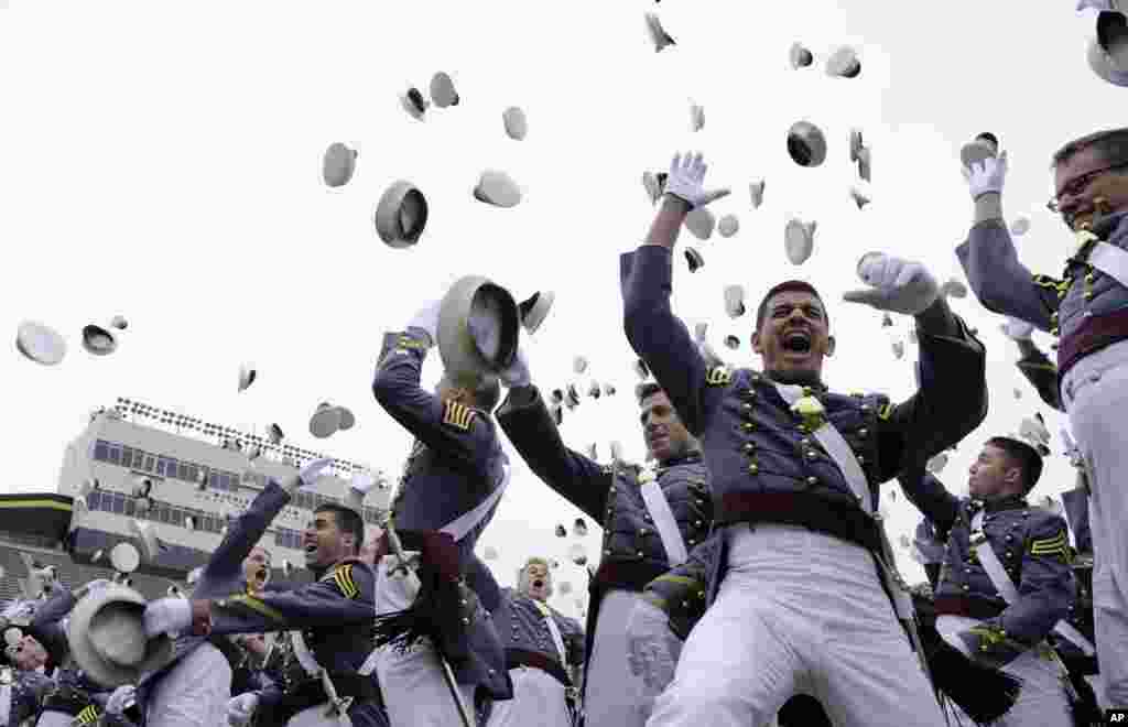 Para wisudawan Akademi Militer AS di West Point, New York melemparkan topi mereka.