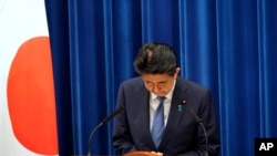Japanese Prime Minister Shinzo Abe bows during a press conference announcing his resignation, at the prime minister's official residence in Tokyo, Japan, Aug. 28, 2020.