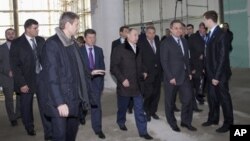 Russian President Vladimir Putin, center, visits the main press center at a coastal Olympic cluster in the Black Sea resort of Sochi, Feb. 7, 2013.