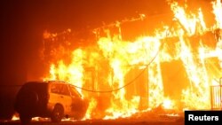A structure is seen engulfed in flames during the Camp Fire in Paradise, California, Nov. 8, 2018. 
