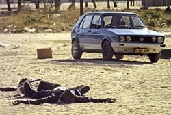 FILE - Two bodies of rebel insurgents lie in a street after sporadic gunfire in the Caprivi strip, Namibia, Aug. 3, 1999.