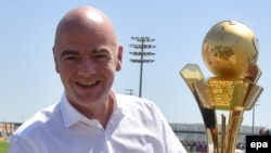 Le président de la FIFA, Gianni Infantino, tient un trophée pour les "travailleurs de la Coupe du monde au Qatar 2016" à Doha, Qatar, 22 avril 2016. epa/ STRINGER