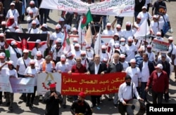 People carry flags and banners as they march during a demonstration organized by the National Federation of Worker and Employee Trade Unions in Lebanon, to mark Labour Day, in Beirut, Lebanon May 1, 2023. (REUTERS/Mohamed Azakir)