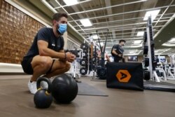 A trainer at Life Time full-service health club works with a client as the club remains open even as Arizona Gov. Doug Ducey has issued an executive order for all gyms to close due to the surge in coronavirus cases in Arizona, July 2, 2020.