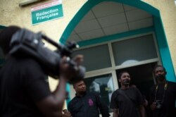 FILE - People with black tape covering their mouths attend a press conference of local journalists to mark World Press Freedom Day at the offices of the Iwacu media group in Bujumbura, Burundi, May 3, 2015.