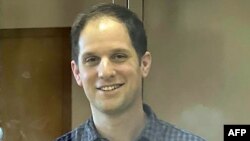 Jurnalis AS Evan Gershkovich, yang ditangkap atas tuduhan spionase, berdiri di dalam kurungan terdakwa selama sidang mengenai sejauh mana penahanan pra-sidangnya, di Moskow, 26 Maret 2024. (Handout / Layanan Pers Pengadilan Kota Moskow /AFP)