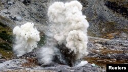 An explosion is pictured at an exploration site of the company Greenland Anorthosite Mining at an anorthosite deposit close to the Qeqertarsuatsiaat fjord, Greenland, September 11, 2021. (REUTERS/Hannibal Hanschke)
