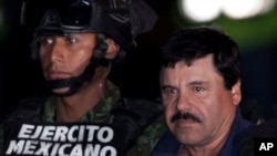 Gembong narkoba Meksiko Joaquin "El Chapo" Guzman, kanan, dikawal tentara dan marinir menuju helikopter, di hanggar federal di Mexico City, 8 Januari 2016. 