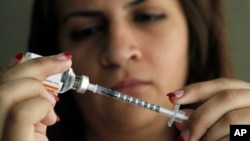 FILE - Judith Garcia fills a syringe as she prepares to give herself an injection of insulin at her home in the Los Angeles suburb of Commerce, Calif., April 29, 2012. The WHO reports diabetes is four times more common than it was in 1980, and now afflicts 422 million adults. 